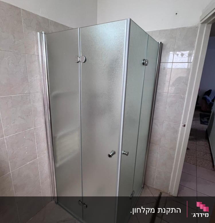 מקלחון זכוכית עם דלתות מתכת בחדר אמבטיה